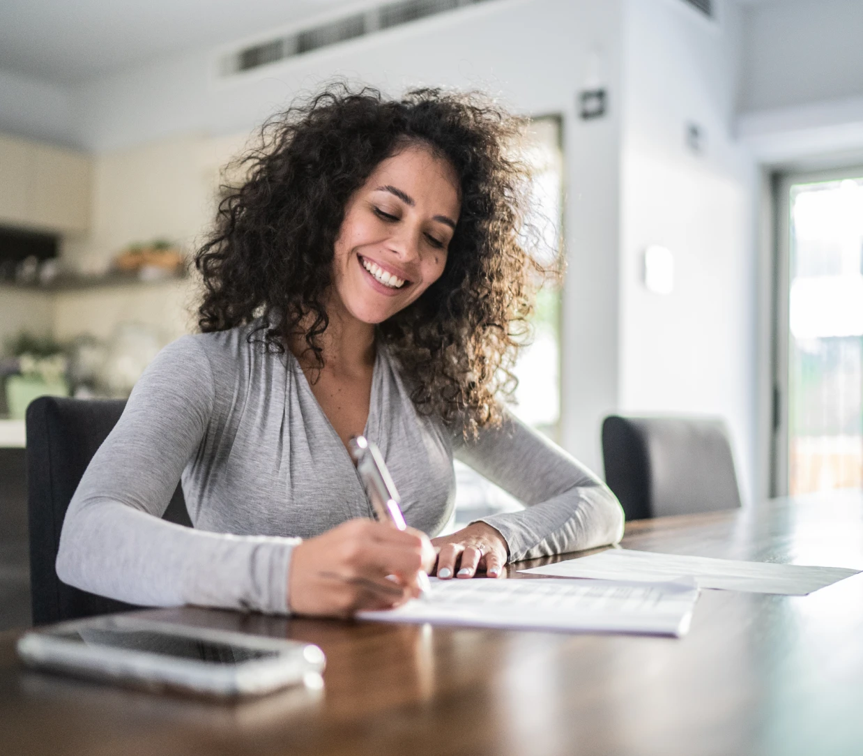 Happy woman writing indoors